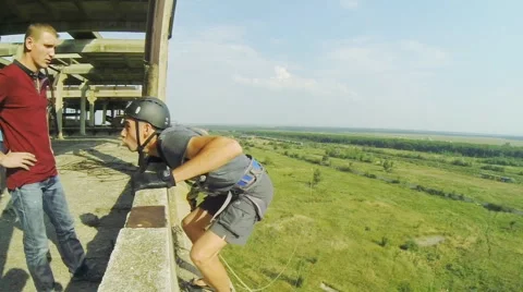 Lanky guy hamming on the parapet, and then jumps back forward Stock Footage 68071748