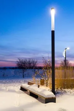 Lantern and bench at sunset in winter Stock Photos