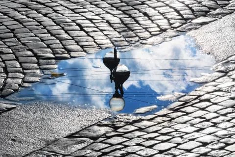 Lantern and sky reflection in the puddle Stock Photos
