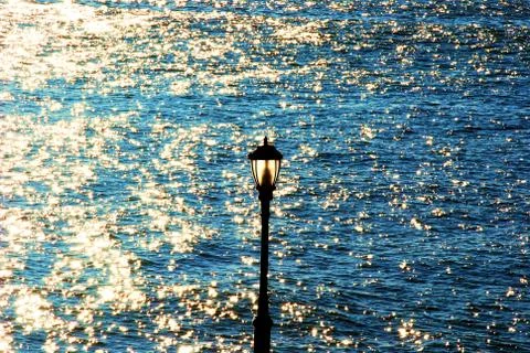 Lantern on the background of sparkling waves Stock Photos