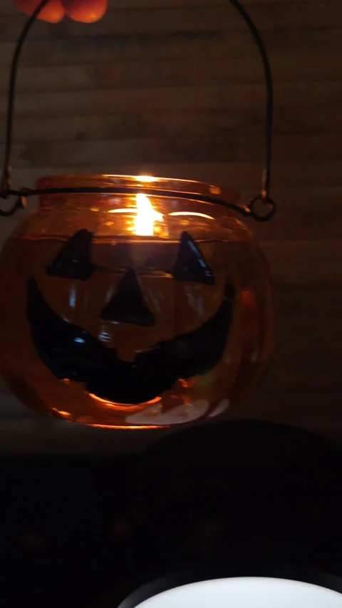 A lantern with a burning candle, a pumpkin in the dark with glare of light, macr Stock Footage 319789361