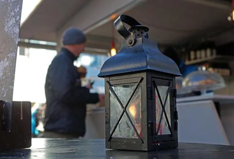 Lantern with candle and light, sundown in the mountains on the background Stock Photos