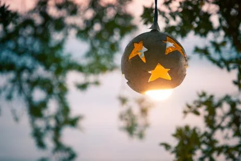 Lantern from the coconut tree with lamp on the background of sunset on the beach Stock Photos
