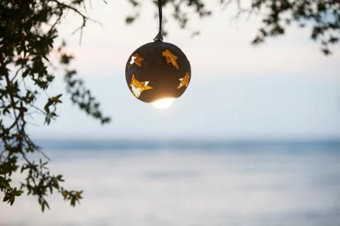 Lantern from the coconut tree with lamp on the background of sunset on the beach Stock Photos