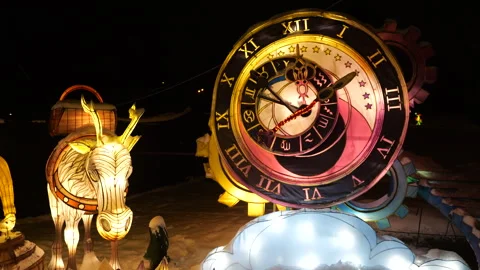 Lantern figures of an old man and a donkey glow brightly in the snowy park. Stock Footage 325913296