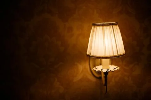 Lantern with flame in retro style on the background of a stone wall of an Stock Photos