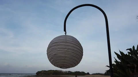  Lantern in the form of a ball swinging in the wind at sunset. Stock Footage 109145072