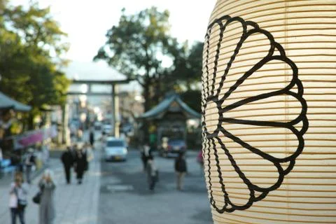 A lantern in front of a defocussed background of shrine goers in Japan Foto stock