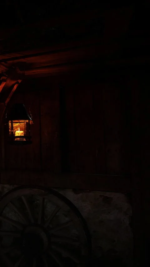 Lantern hangs in dark room showing warm light with wooden walls Stock Footage 339768215