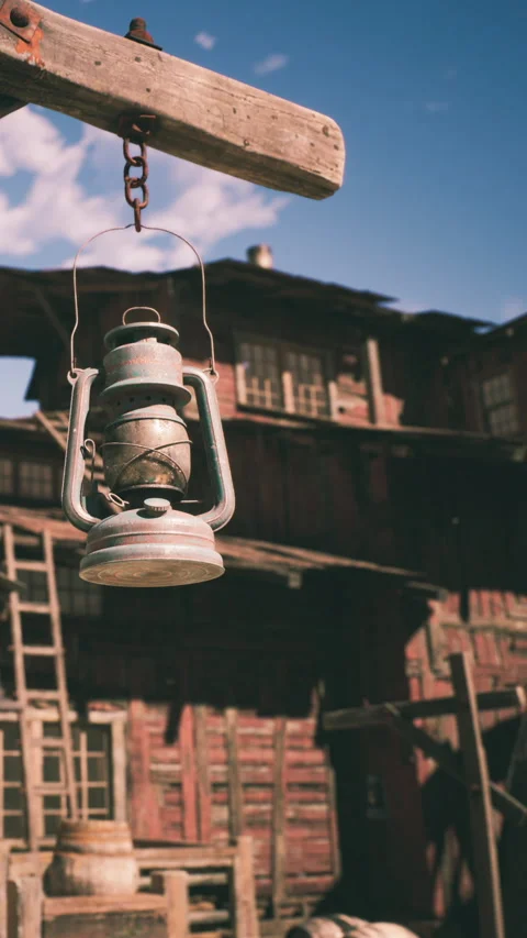 Lantern hangs outside a rustic building in a rural setting during daylight Stock Footage 341019747