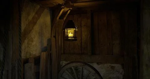 Lantern illuminates rustic wooden interior of old structure in dim light Stock Illustration