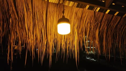 Lantern with a light bulb under a canopy made of bamboo and straw Stock Footage 309129264