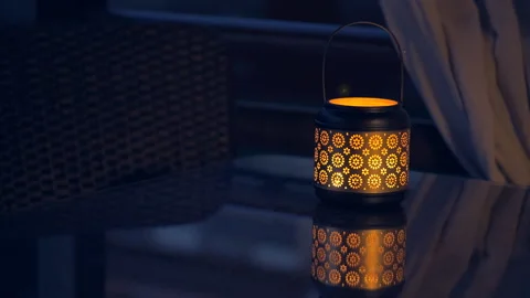 Lantern with lighted candle on table with  lights of fireflies at night  . Stock Footage 90367035