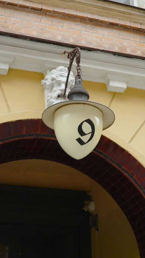 Lantern on old building in shape of acorn with number 9 on frosted glass bulb. Vidéo 278731796