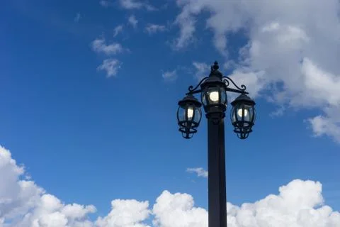 The lantern in the old style on the background of blue sky and clouds in Stock Photos