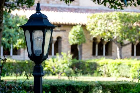 Lantern post in courtyard with stone arcade backdrop 库存照片