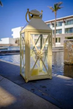 A lantern stands next to a swimming pool Stock Photos
