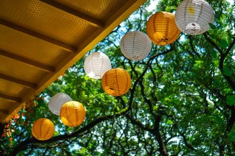 Lanterns are hung under the bridge with a background of sky and green trees Stock Photos