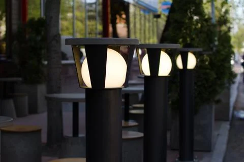Lanterns with bright lighting of opened summer cafe Stock Photos