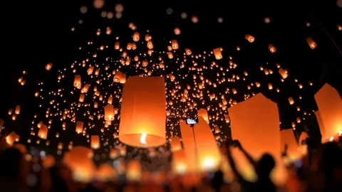 Lanterns of light is released into the night sky by multi ethnic crowd. Stockbeeldmateriaal 119019197