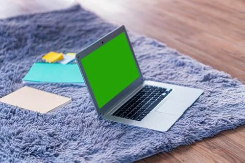 Lap top computer with green screen on gray carpet Stock Photos