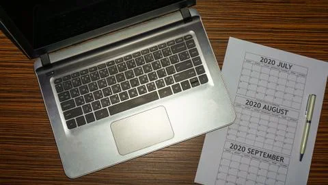 A lap top computer notebook with a pen and calender for business or holiday p Stock Photos