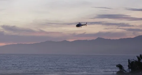 LAPD helicopter flies past red and orange sunset clouds 4K Stock Footage 89503834
