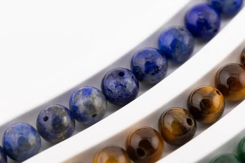 Lapis lazuli gemstone bead strands close up on white tray Stock Photos