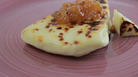 Lapland squeaky cheese with cloudberry jam on a pink plate Stock Footage 60406688