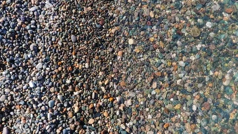 The lapping of the clear sea waves on a pebble beach Stock Footage 106506398