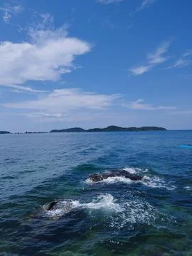 Lapping Waves and Distant Islands Stock Photos