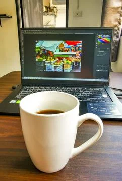 Laptop and coffee cup on table showing digital nomad lifestyle Thailand. Stock Photos