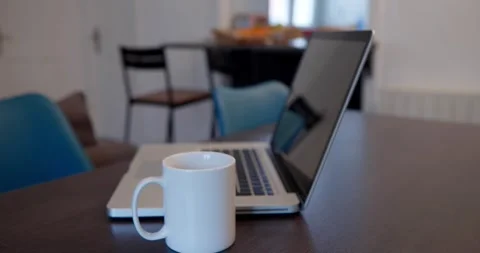 A laptop and a coffee mug sit on a wooden table Stock Footage 334651274