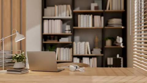 A laptop and decor on a table, with a blurred bookshelf in the background o.. Stock Illustration