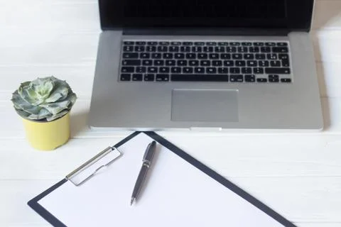 Laptop and documents in the workplace. Stock Photos