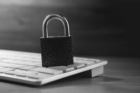 Laptop and lock on table, security concept Stock Photos