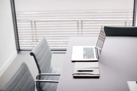 Laptop And Notebook On Table In Empty Meeting Room Of Modern Office Stock Photos