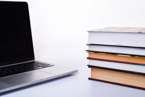 Laptop and stack of books on a white background. Stock Photos