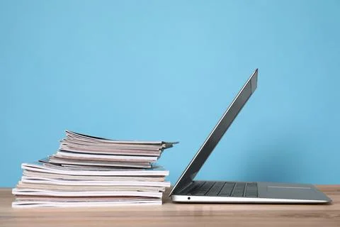 Laptop and stack of magazines on wooden table Stock Photos