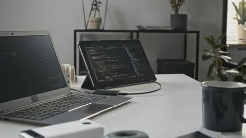 Laptop and Tablet Displaying Programming Code in Tech Office 動画素材 336710397