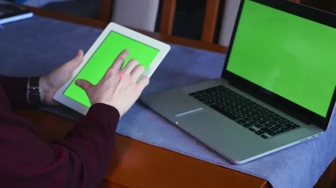 Laptop and tablet pc lying on the table. Man is using tablet pc. Green screen Stock Footage 61281122