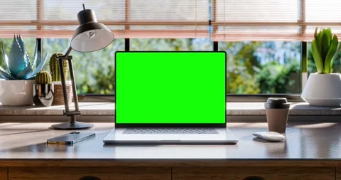 A laptop with a blank green screen is placed on a stylish wooden desk withi.. Stock Footage 262432307
