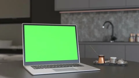 Laptop with blank green screen, standing on table at home. Computer mock up with Stock Footage 221144882