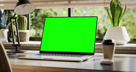 A laptop with a blank screen is placed on a stylish wooden desk within a lo.. Stock Footage 261743561