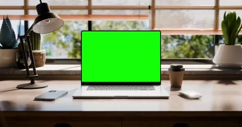 A laptop with a blank screen is placed on a stylish wooden desk within a lo.. Stock Footage 261966475