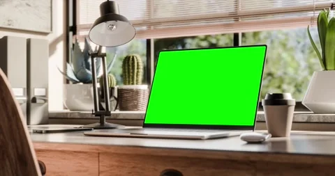 A laptop with a blank screen is placed on a stylish wooden desk within a lo.. Stock Footage 262442579