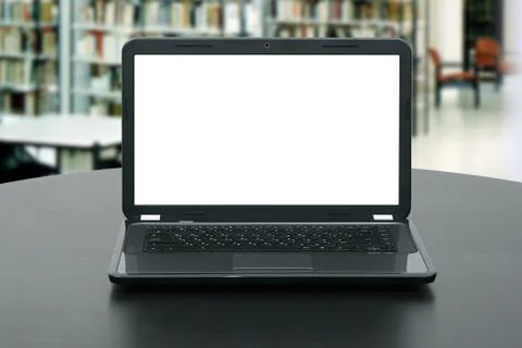 Laptop with blank screen on the table in library Stock Photos