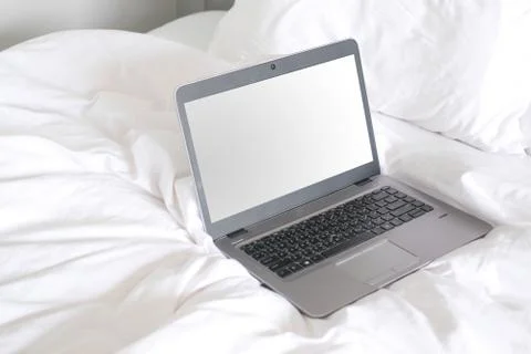 Laptop blank screen on white bed with copy space for design, Technology conce Stock Photos