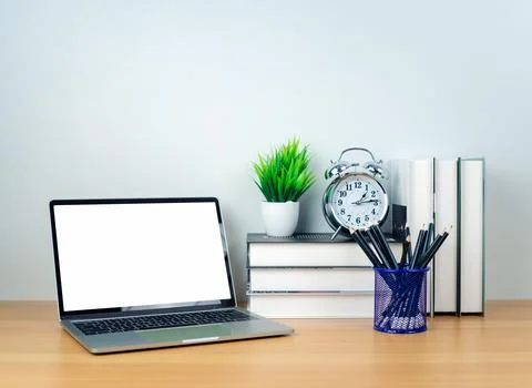 Laptop with blank screen on white table and office supplies on wooden backg.. Stock Photos