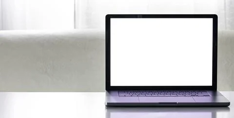 Laptop with a blank white screen on a blurred light background. Stock Photos